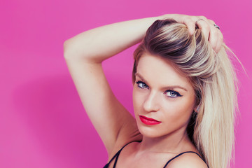 Naklejka premium Beautiful blonde woman portrait holding her hair and looking at camera