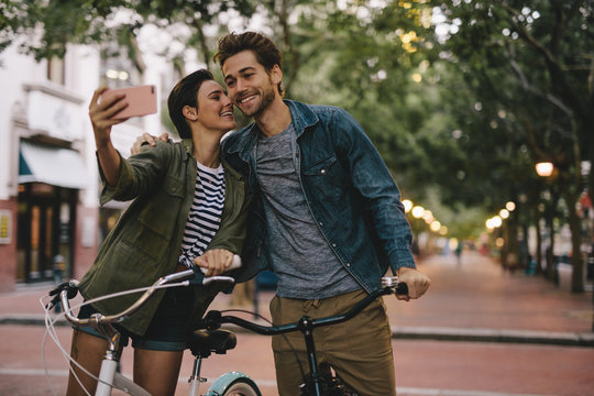 Romantic couple taking selfie with bicycles