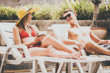 Young couple enjoying summer time at swimming pool.