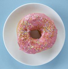 One pink donut on blue background