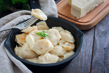 Fried dumplings with cabbage in a portioned cast-iron frying pan, selective focus