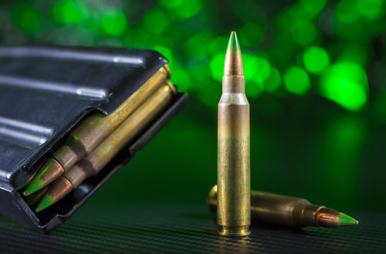 M855 cartridges and magazine with green background
