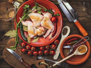 raw chicken wings. cooking. spices and vegetables. old kitchen accessories. wooden background