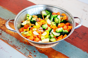 pot with mixed vegetables on wooden table