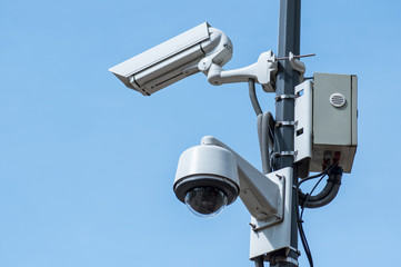 closeup of security camera in the city on blue sky background