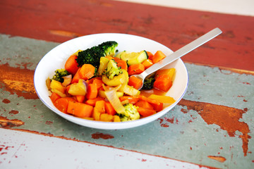 white plate with mixed vegetables on wooden table