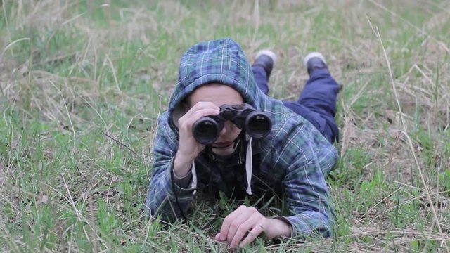 Close up of a man looking through binoculars, outdoors.