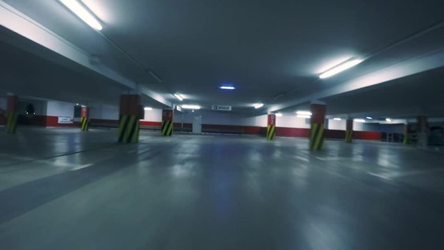 Slow motion: racing drone flying low in parking garage. First person view from a drone. Quadcopter race inside dark building. Shot with 2.7K 50fps.