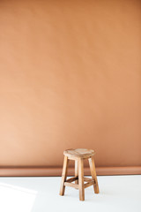 Empty wooden stool on brown background