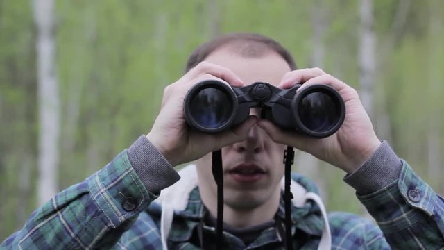Tourist man looking through binoculars