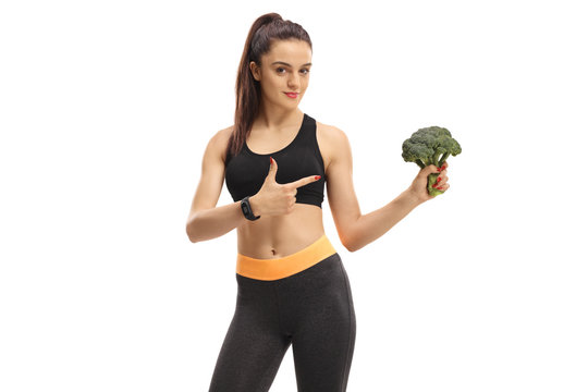Fitness woman holding broccoli and pointing