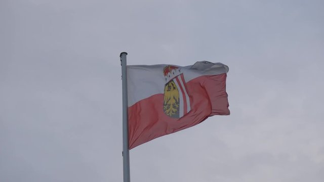 Austrian flag on a cloudy sky background