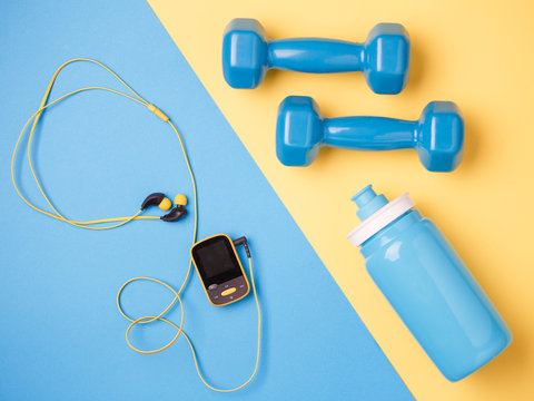 Photo of player, dumbbells, bottle of water on blue and yellow background