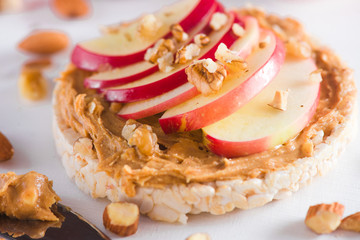 Apple crisp bread toast with apple slices, peanut butter, almonds and walnuts. Healthy breakfast...
