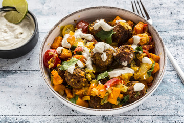 Vegetarian bowl with sweet potato, tomato and falafel, yogurt dip and parsley