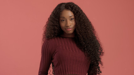 Beauty mixed race african american woman with hair blowed in air smiling at camera