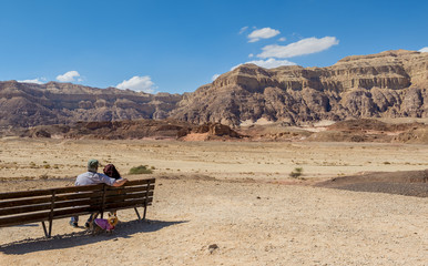 Couple of happy seniors looking at valley of geological Timna park. It is located 25 km north of Eilat (Israel), combines beautiful scenery with unique geology and variety of family activities
