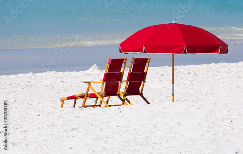 Beach Chairs And Red Umbrella On White Sand Beach With Blue