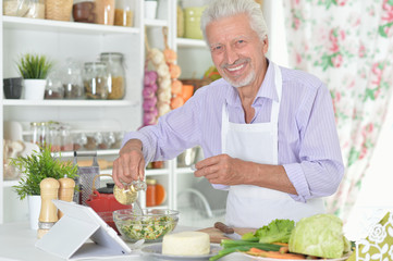 Senior man  preparing dinner in kitchen