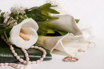 gold wedding rings with a bouquet of white calla lily and pearls