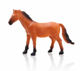 Children´s small plastic brown - black horse isolated on the white background with shadow reflection. Small childish toy in the shape of horse. Miniature of brown horse on white background with shadow