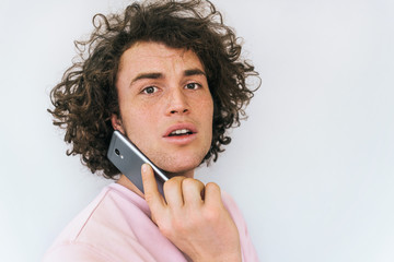 Closeup horizontal portrait of handsome male with curly hair has communication with friend via...