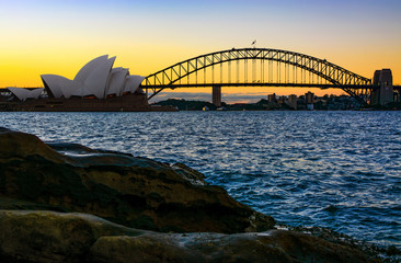 Obraz premium Iconic Sydney Harbour Bridge seen from natural shoreline at sunset