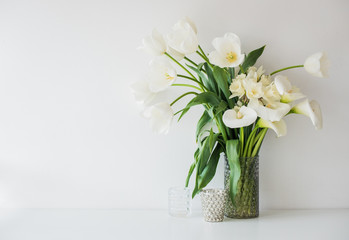 Fototapeta na wymiar Large bouquet of white spring flowers in a vase, daffodils, tuli