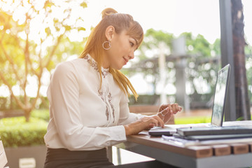 Asian woman using tablet and laptop