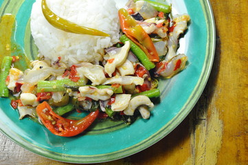 spicy stir fried squid with basil leaf and plain rice on plate