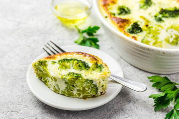 Broccoli egg casserole piece on concrete background. Selective focus, space for text. 