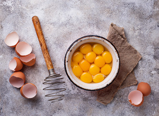Bowl with eggs yolks and whisk - obrazy, fototapety, plakaty