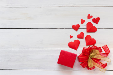 Red heart origami paper and present box on white woodern background, romance and Velentine's day concept