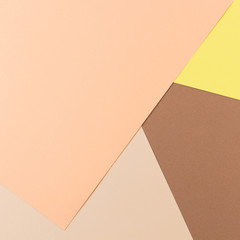 Color papers geometry composition background with yellow pink, beige and brown tones.