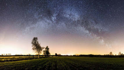 Panorama of a milky way over fields