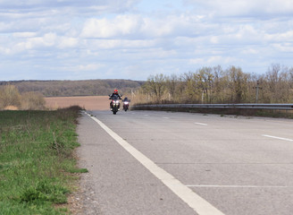 Male motorcyclist at the wheel of a racing motorcycle on a high-speed empty road. with pleasure passing an empty road to travel by motorcycle. Place for text, extreme sport, freedom concept