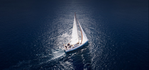 Amazing view to Yacht sailing in open sea at windy day. Drone view - birds eye angle. - obrazy, fototapety, plakaty