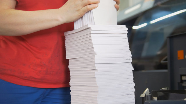 Hands Of Female Worker Folds A Paper Stacks In Typography