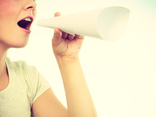 Woman screaming through megaphone made of paper