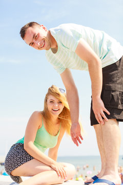 Man helping girlfriend to get on fenece