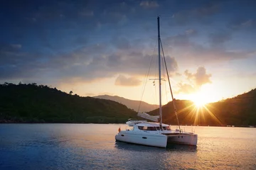 Fototapeten Yacht - Catamaran in the tropical sea at sunset © dell