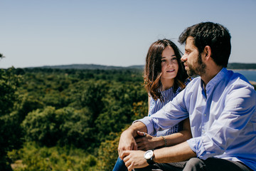 Obraz premium .Young happy couple in love enjoying a nice spring day in the countryside. Located on a hill overlooking a large lake.