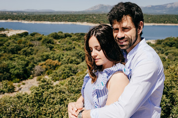 Obraz premium .Young happy couple in love enjoying a nice spring day in the countryside. Located on a hill overlooking a large lake.