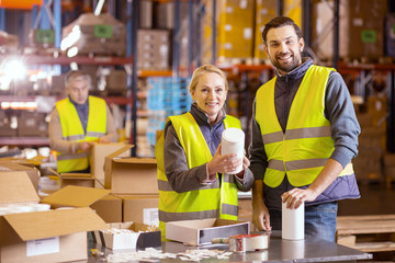 Wholesale retail. Joyful positive people looking at you while working in the wholesale retail industry 