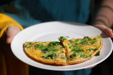fried eggs with tomatoes, onions and parsley on a white plate
