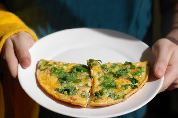 fried eggs with tomatoes, onions and parsley on a white plate