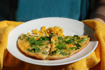 fried eggs with tomatoes, onions and parsley and corn