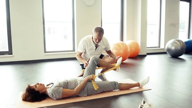 Senior physiotherapist working with a female patient.