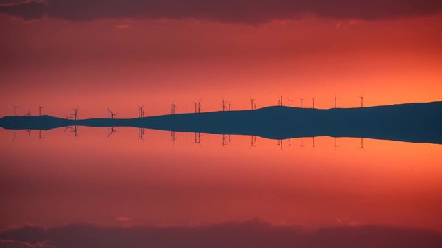 Clean Energy with wind turbines at sunset, time lapse reflection
