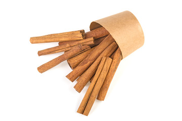 a lot of cinnamon sticks in a paper cup on a white background